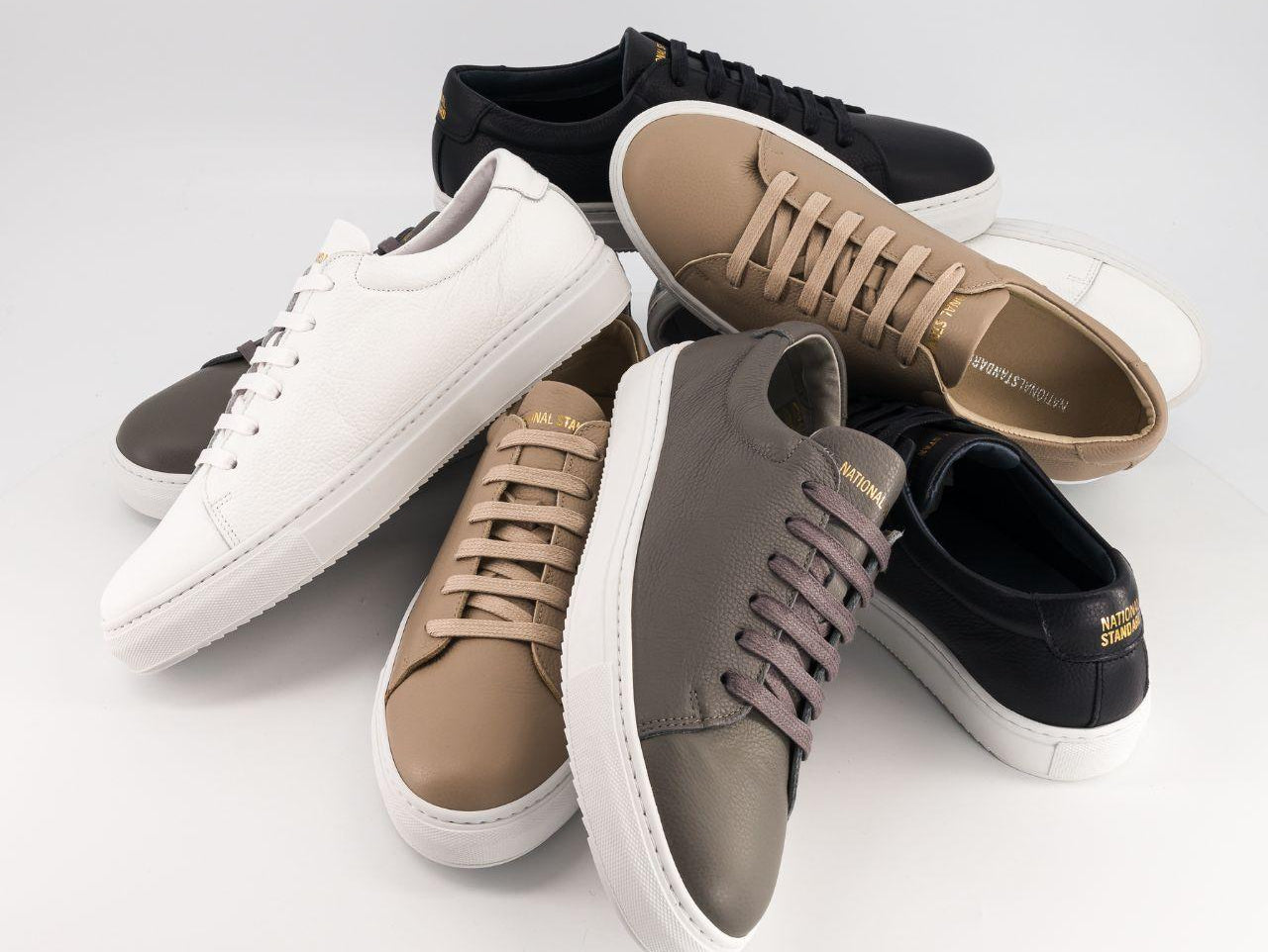 National Standard premium sneakers in assorted neutral colors on white background