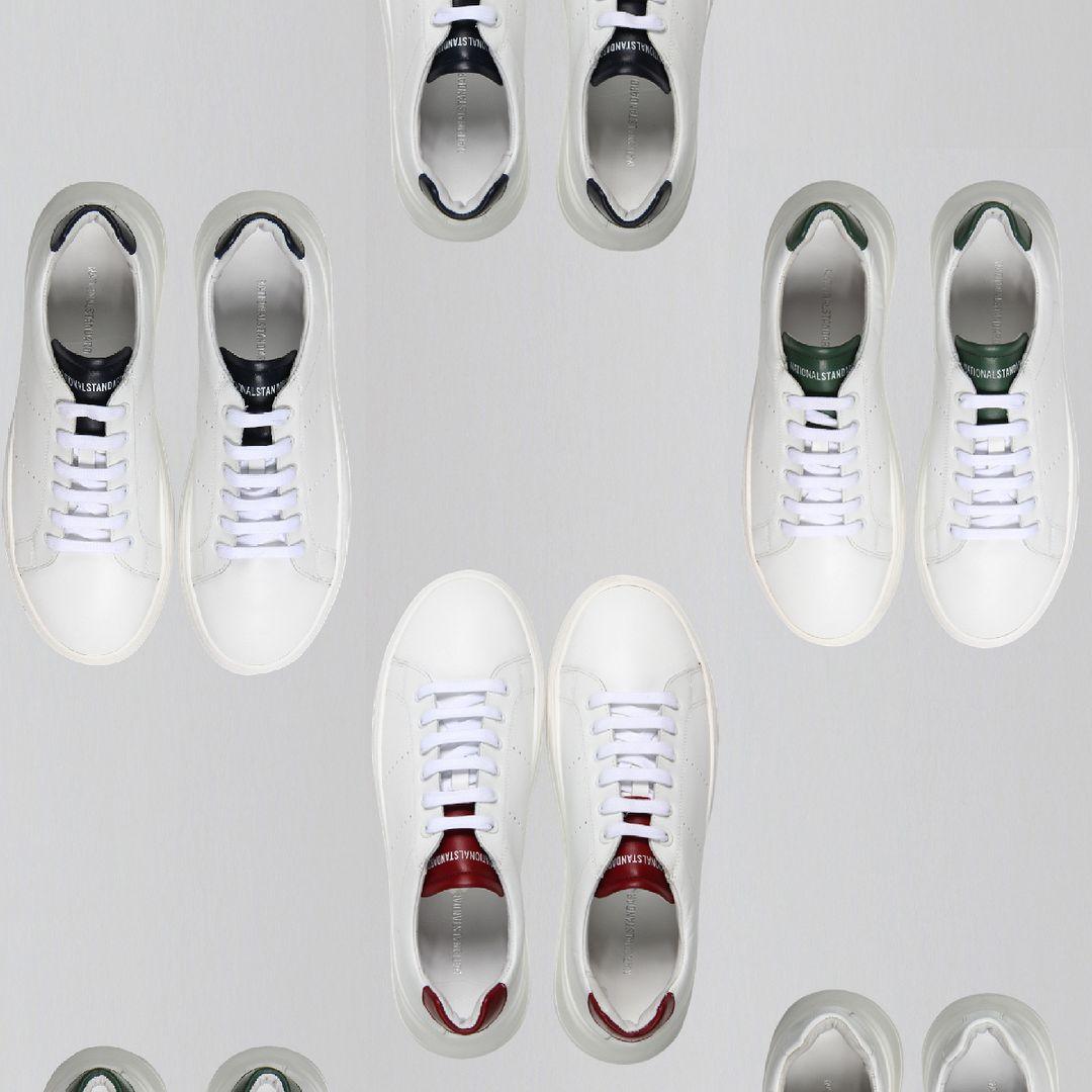 National Standard premium white sneakers with colored heel tabs arranged on a light background