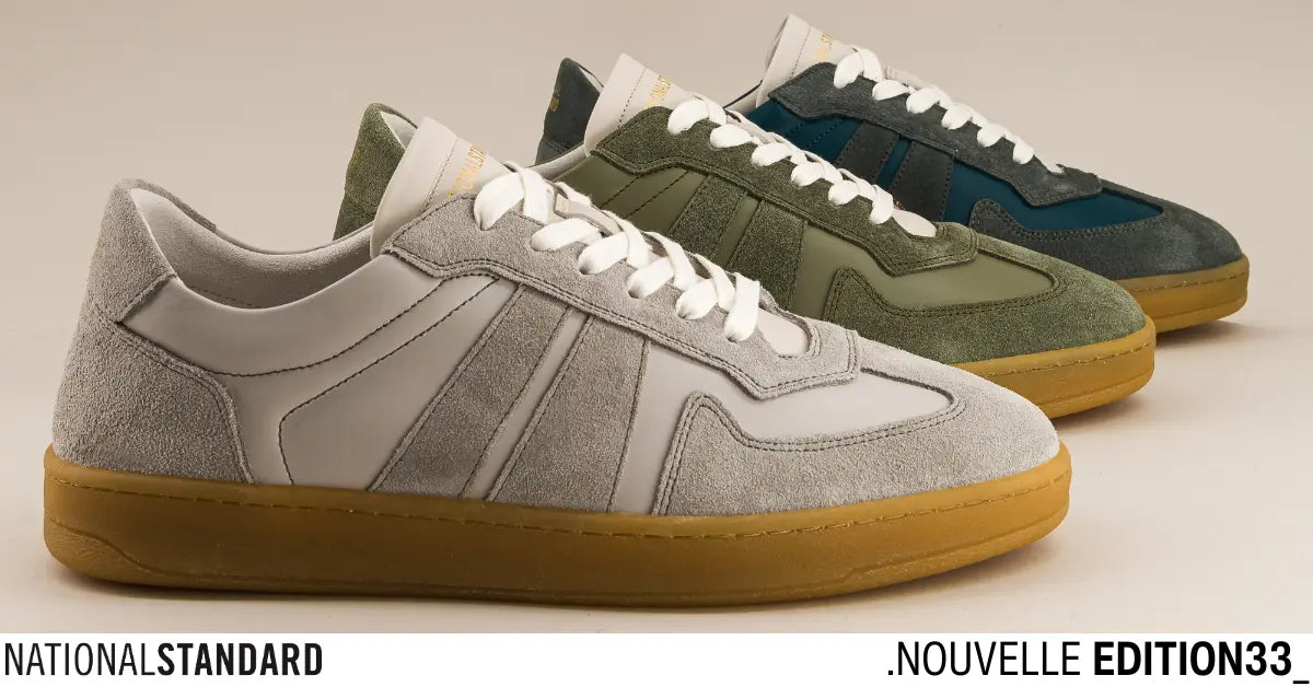 National Standard Edition 33 premium suede sneakers in gray, green, and blue with gum soles.