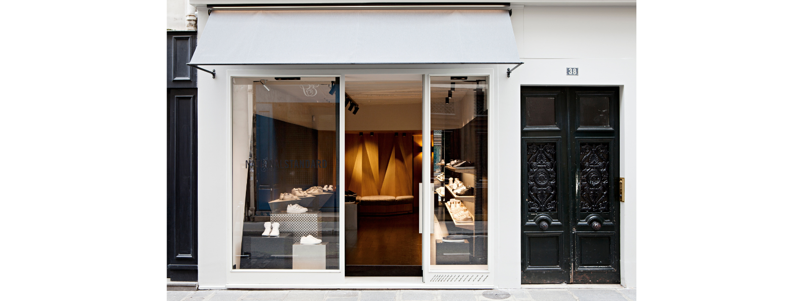 National Standard sneaker boutique exterior with modern glass storefront, premium shoes on display